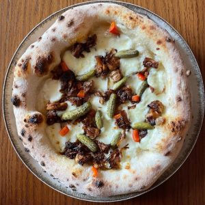 Homemade Neapolitan style pizza with jackfruit and pickles. Baked in an Ooni outdoor pizza oven
