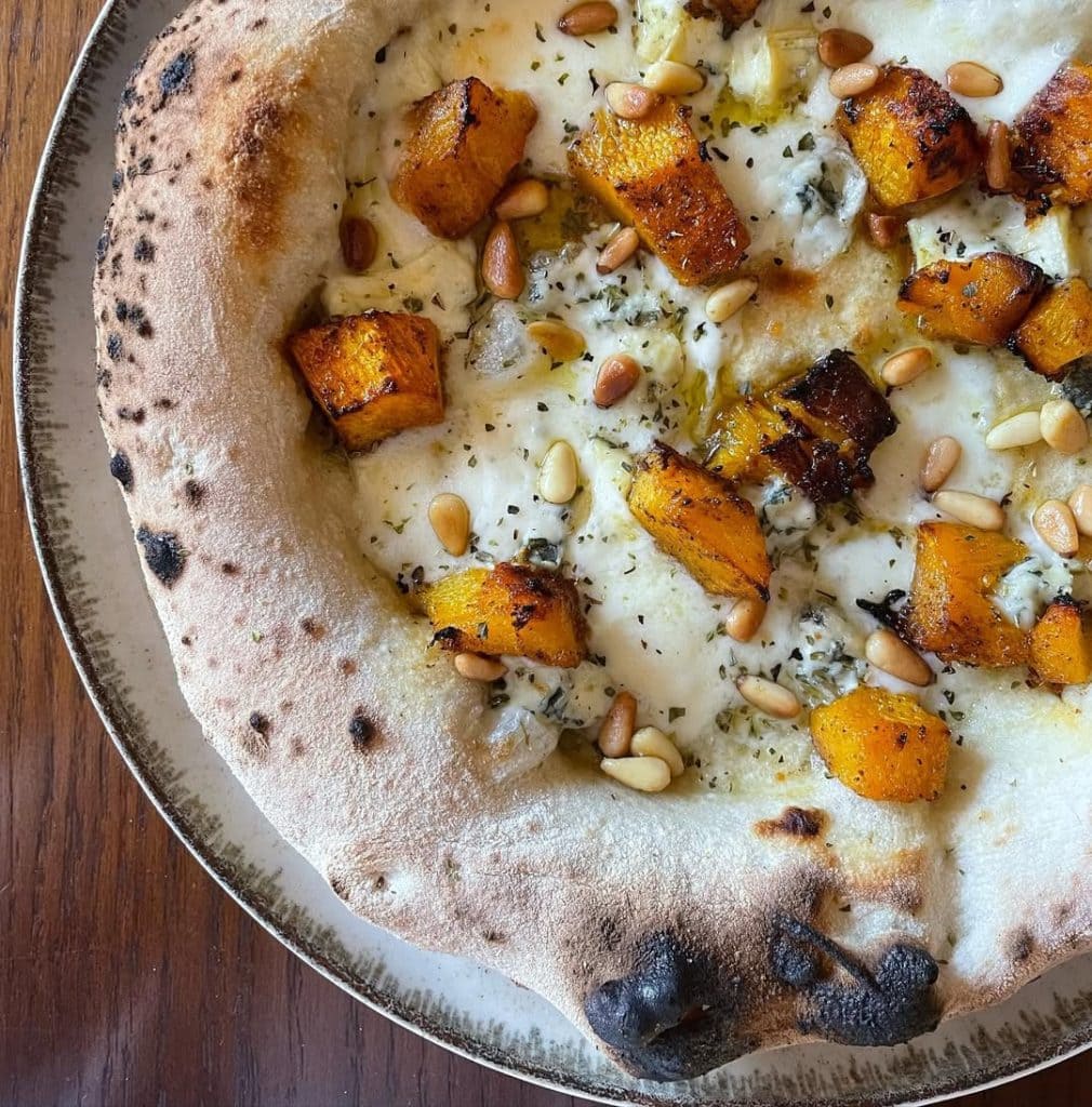 Homemade Neapolitan style pizza topped with mozzarella, pumpkin, blue cheese, pine nuts, oregano and EVOO. Baked in our Ooni outdoor pizza oven.