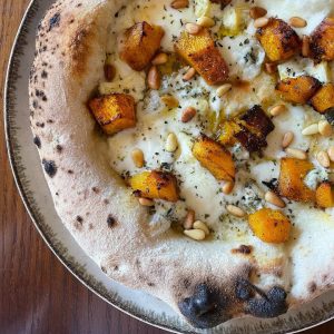 Homemade Neapolitan style pizza topped with mozzarella, pumpkin, blue cheese, pine nuts, oregano and EVOO. Baked in our Ooni outdoor pizza oven.