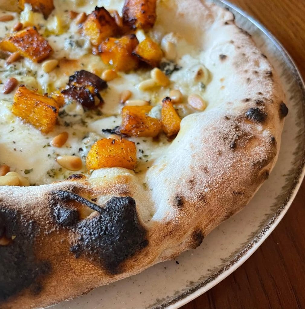 Homemade Neapolitan style pizza topped with mozzarella, pumpkin, blue cheese, pine nuts, oregano and EVOO. Baked in our Ooni outdoor pizza oven.