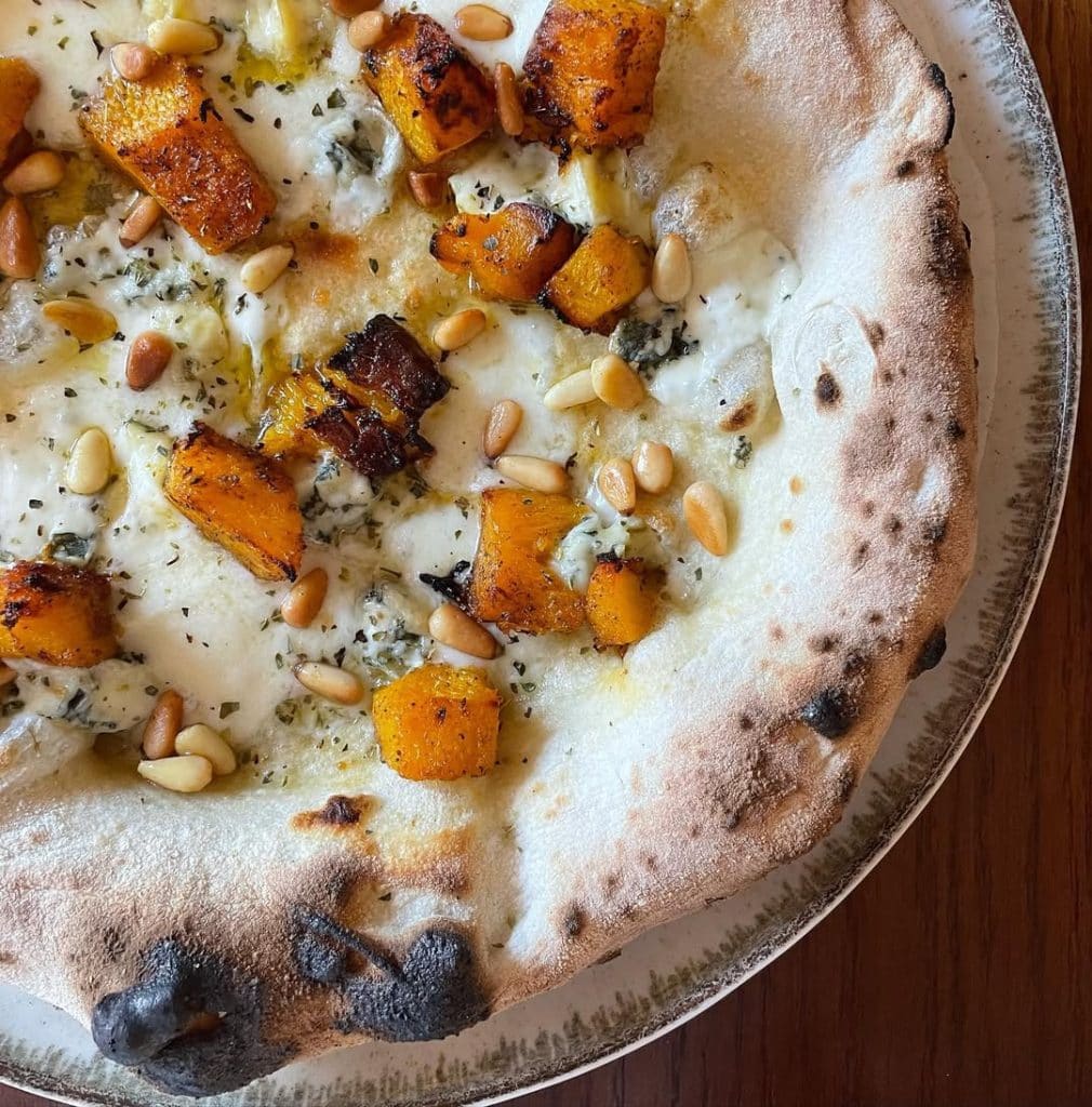 Homemade Neapolitan style pizza topped with mozzarella, pumpkin, blue cheese, pine nuts, oregano and EVOO. Baked in our Ooni outdoor pizza oven.