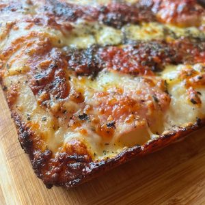 Homemade Detroit style pizza topped with mozzarella, grana pdano, Neapolitan style tomato sauce, oregano and EVOO. Baked in our Ooni Volt pizza oven.
