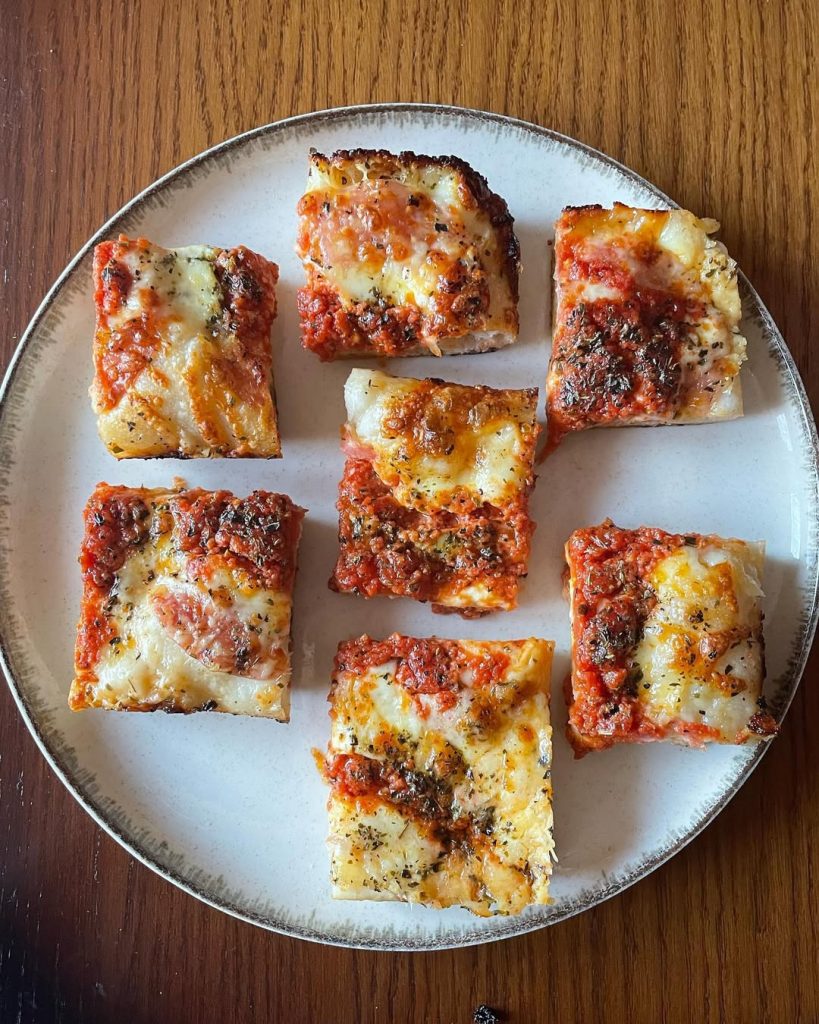 Homemade Detroit style pizza topped with mozzarella, grana pdano, Neapolitan style tomato sauce, oregano and EVOO. Baked in our Ooni Volt pizza oven.