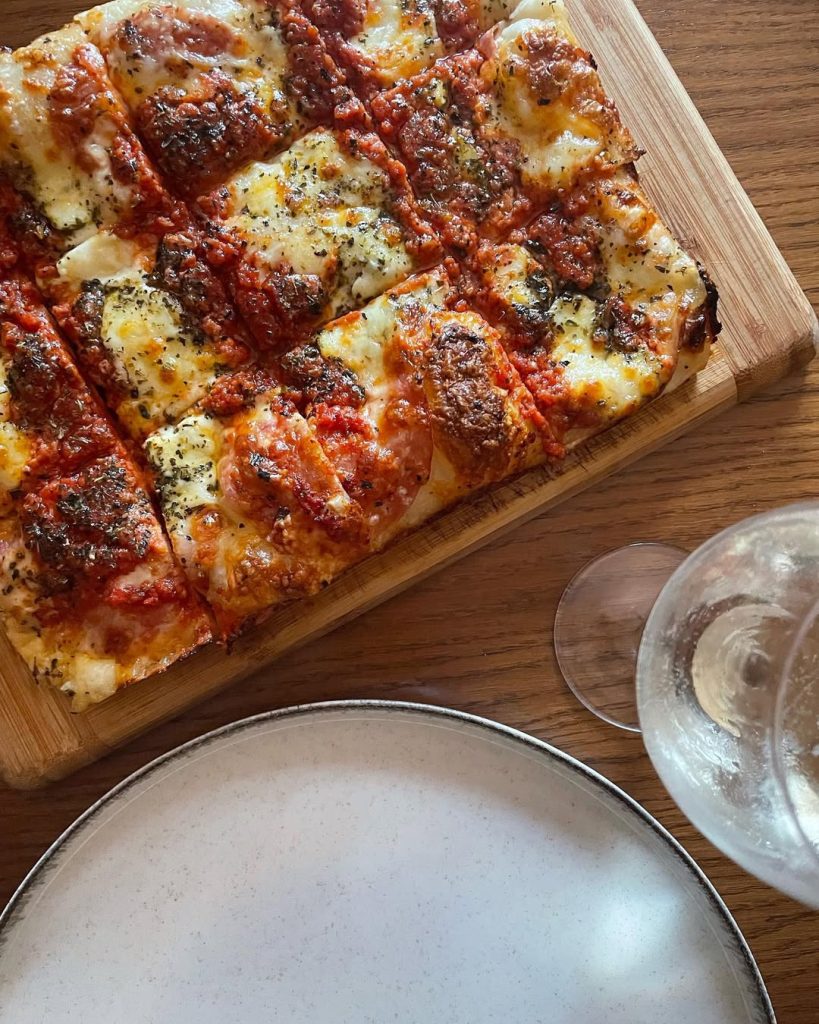 Homemade Detroit style pizza topped with mozzarella, grana pdano, Neapolitan style tomato sauce, oregano and EVOO. Baked in our Ooni Volt pizza oven.