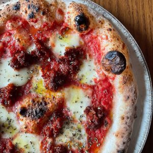 Neapolitan-style Nduja pizza topped with mozzarella fior di latte, rich tomato sauce, and spicy Calabrian nduja, finished with oregano and EVOO