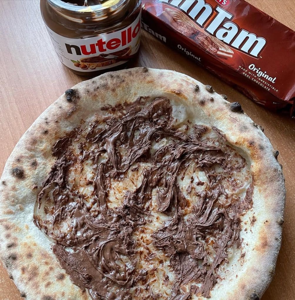 Pizza with Nutella, served warm on a wooden board.